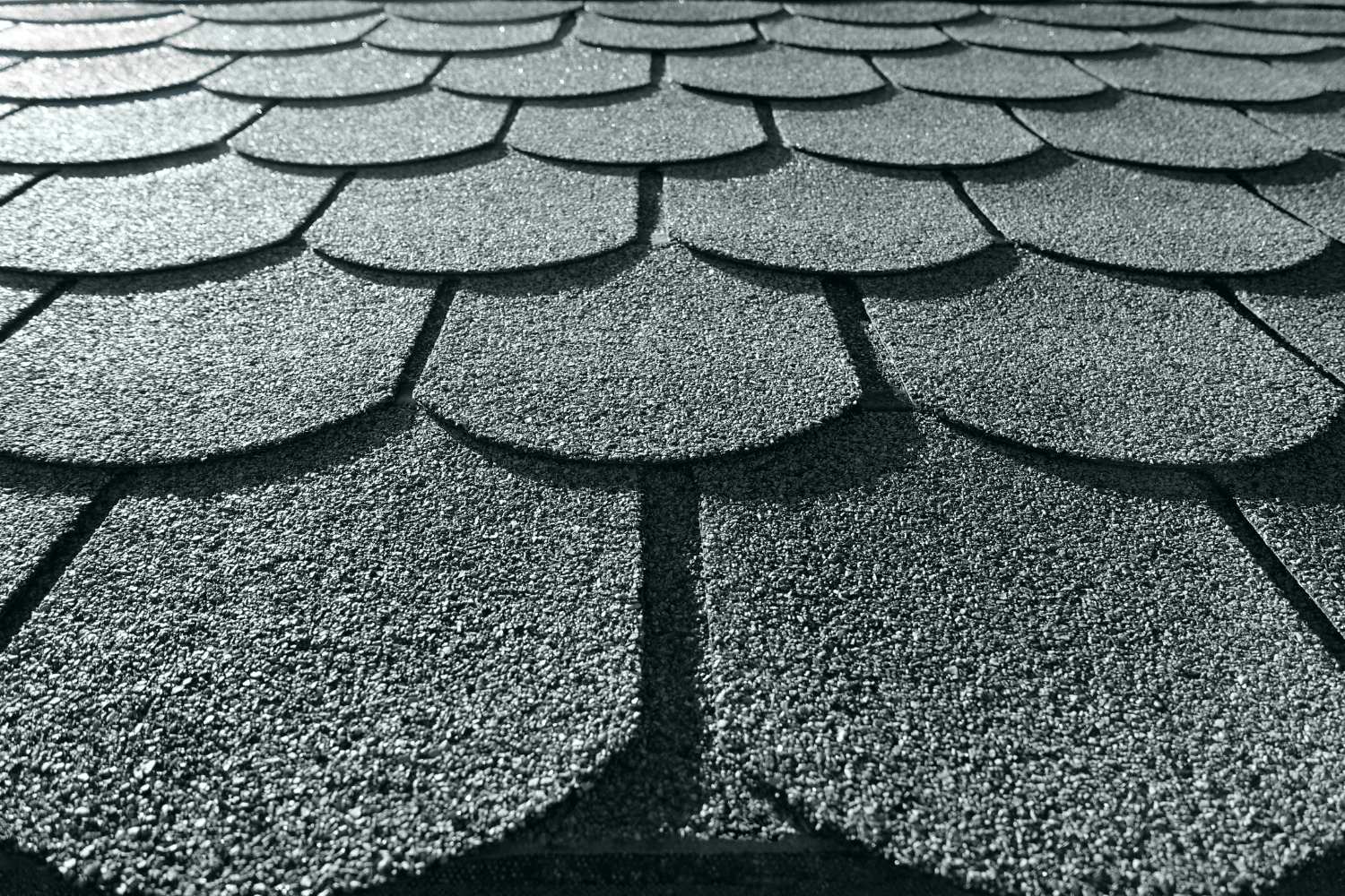 A close-up view of asphalt shingles showcasing their texture and layers, illustrating what is asphalt shingle roof. 