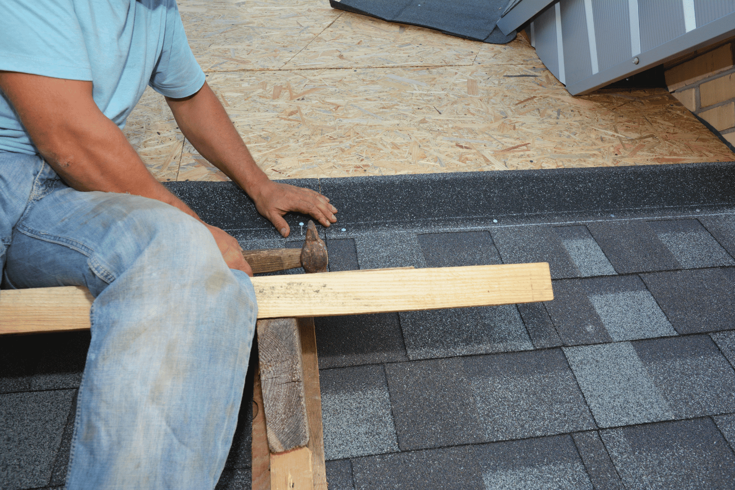 A professional roofer installing asphalt shingles on a roof, illustrating the installation process of asphalt shingle roofs. 