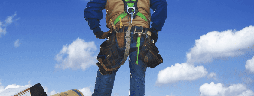 An image of a construction worker inspecting a roof, preparing for a roof replacement.