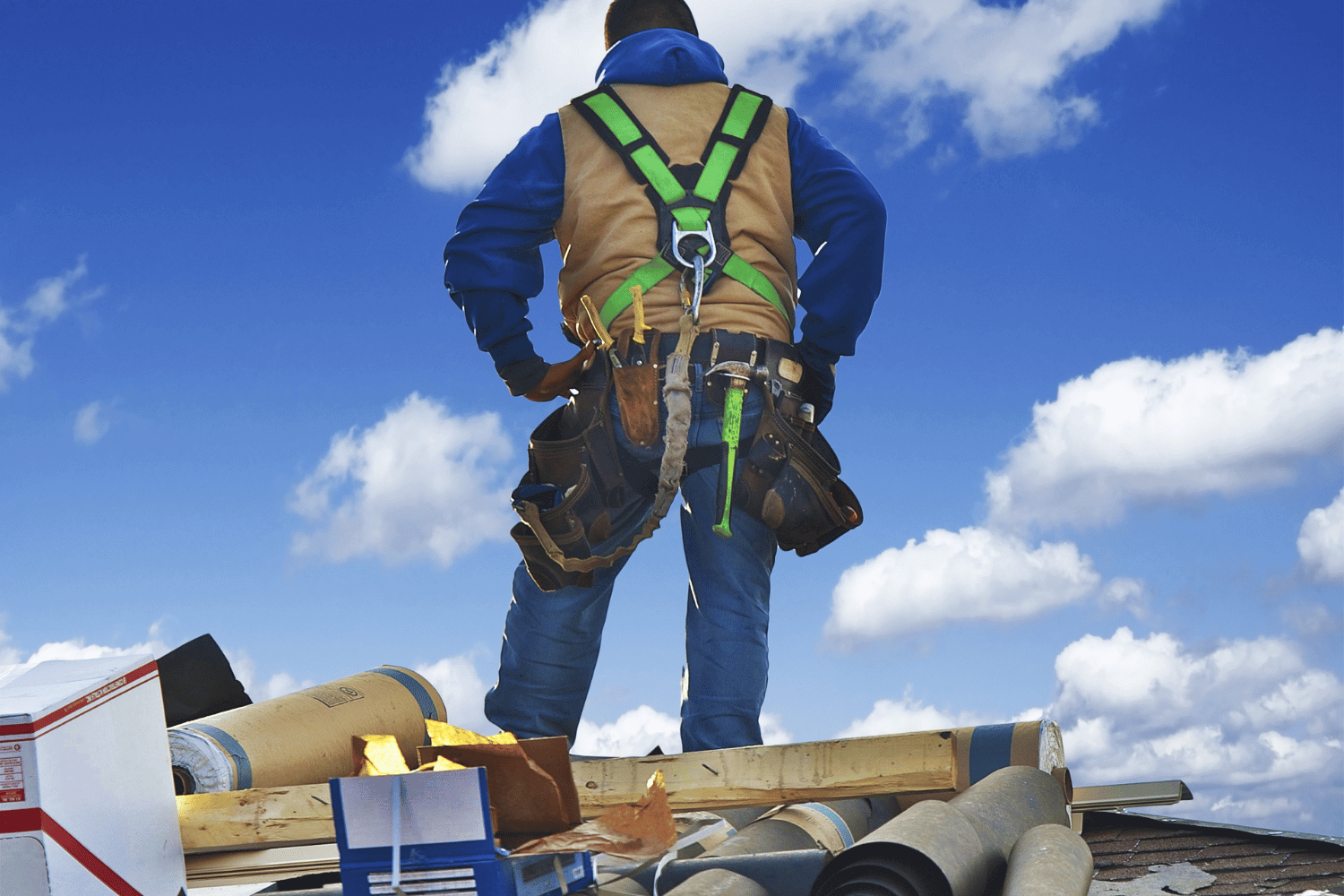 An image of a construction worker inspecting a roof, preparing for a roof replacement. 