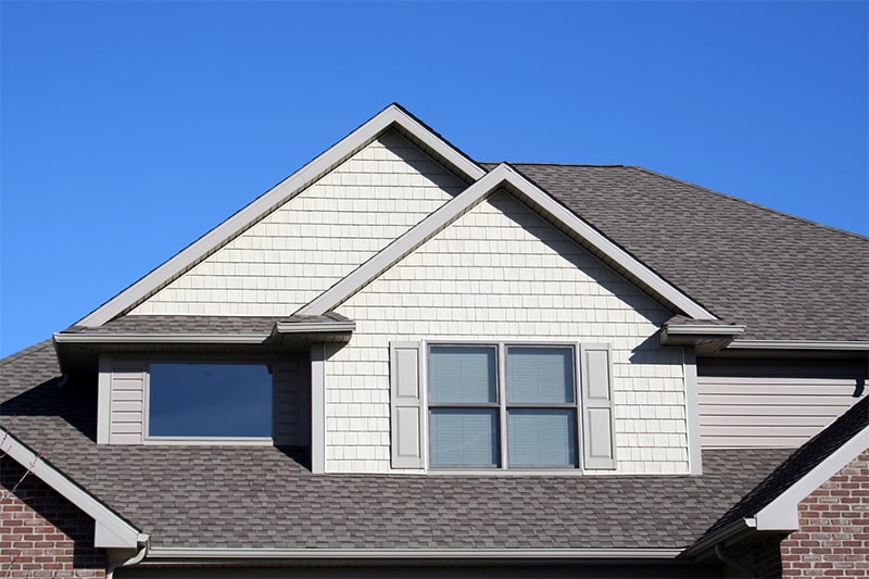 A house characterized by a gray roof and two windows, presenting a classic and understated architectural style