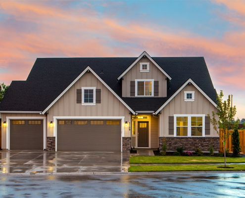 A house with an attached garage and a neatly paved driveway, emphasizing a suburban lifestyle