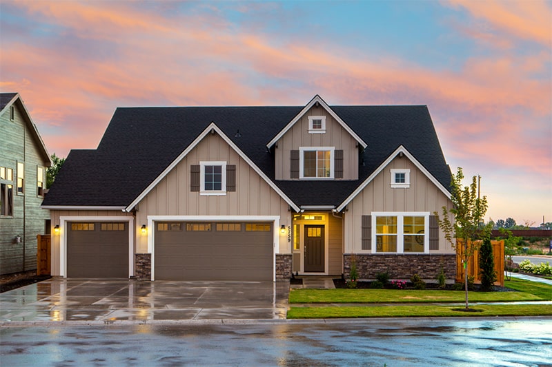 A house with an attached garage and a neatly paved driveway, emphasizing a suburban lifestyle