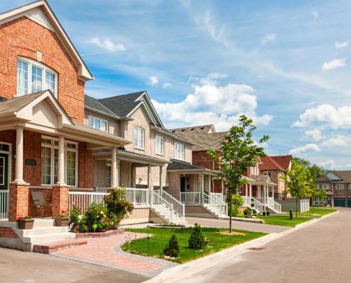 A row of residential houses with a sidewalk, illustrating a typical neighborhood scene