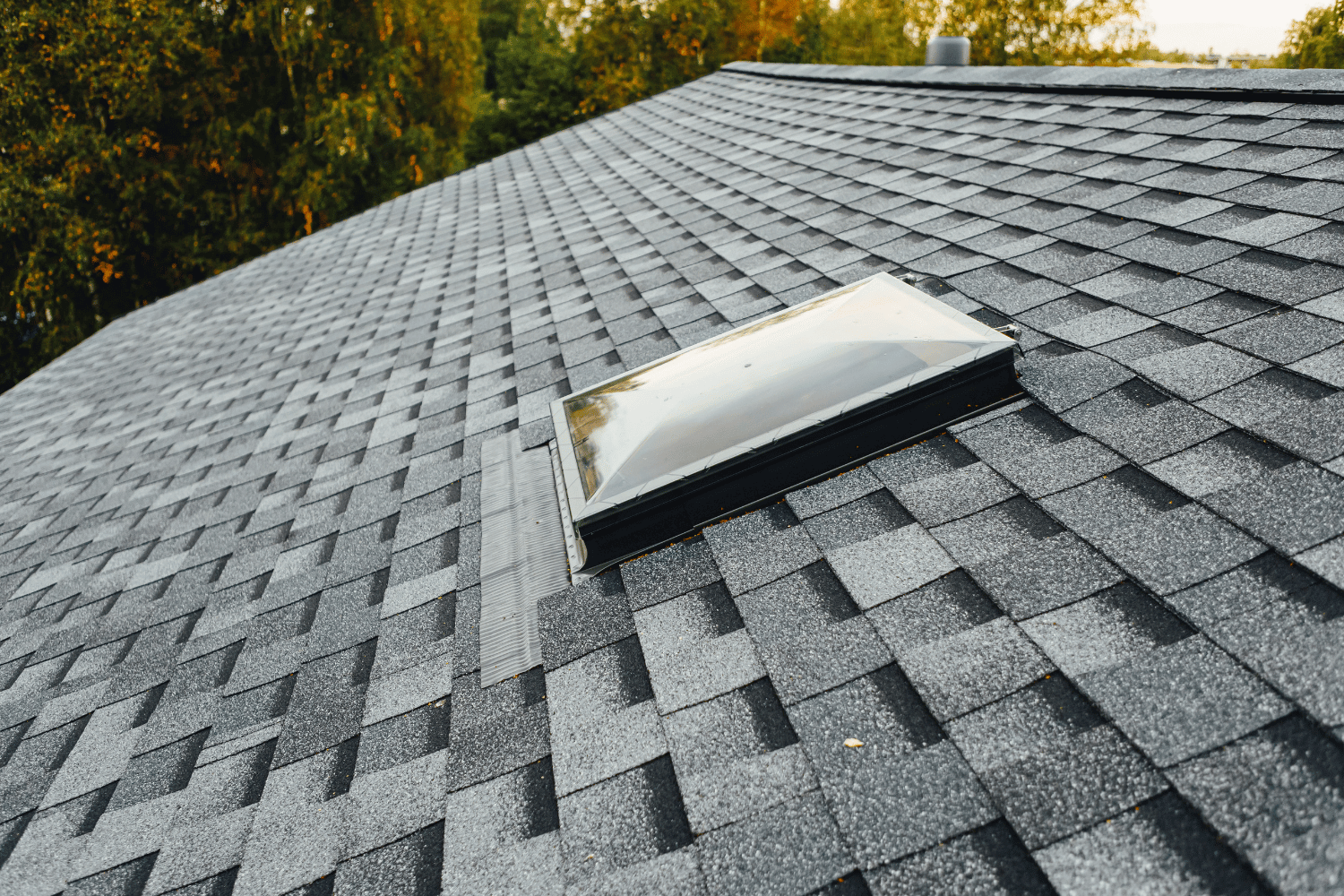 A professional roofer applying roofing cement to secure a loose shingle.