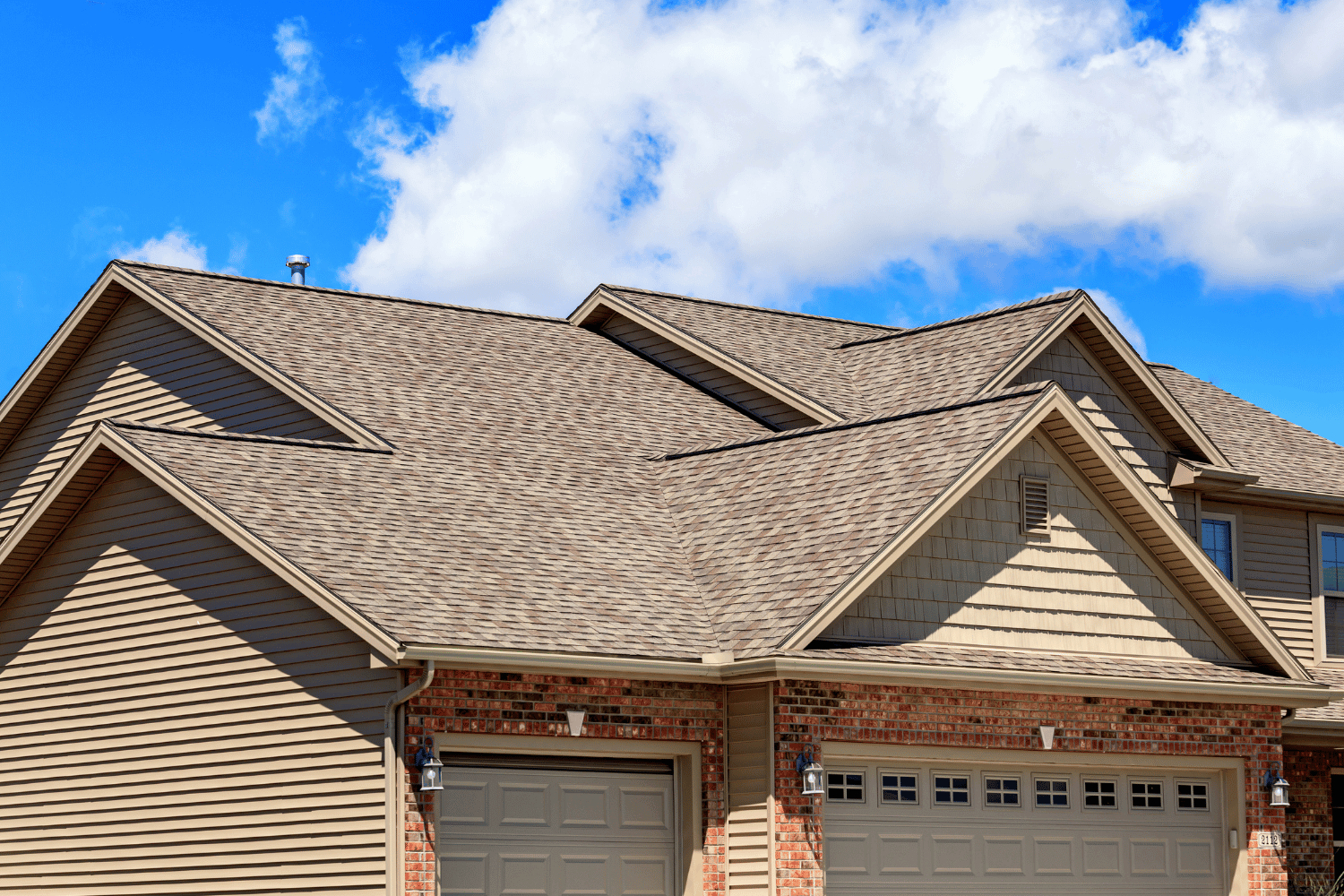 A professional roofer performing roof repair work on a residential building.