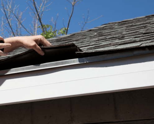 A detailed view of shingle roof components including underlayment and drip edge.