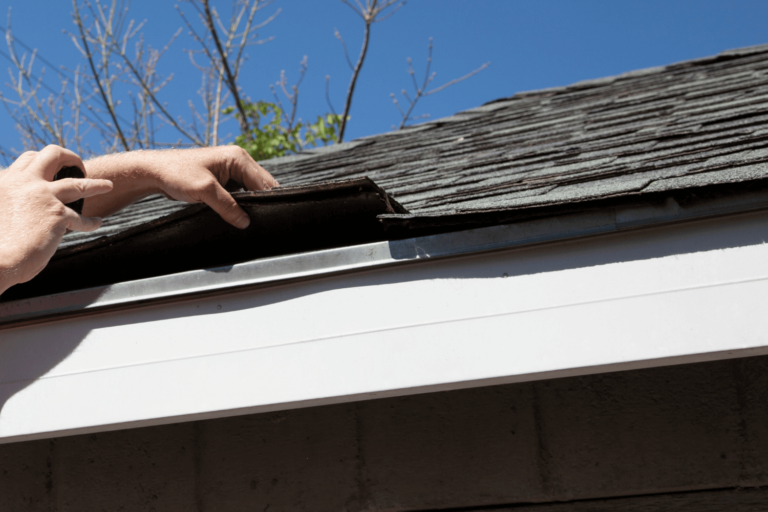 A detailed view of shingle roof components including underlayment and drip edge.