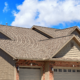 A family standing in front of their home with an asphalt shingle roof.