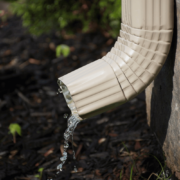 A properly installed downspout directing water away from the house foundation.