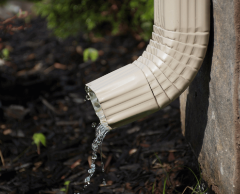 A properly installed downspout directing water away from the house foundation.