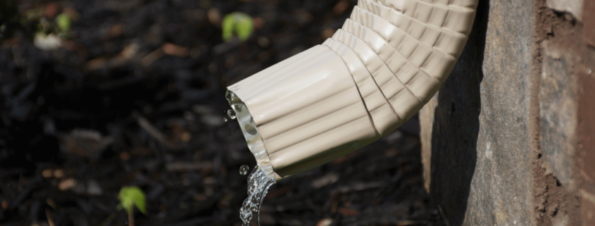 A properly installed downspout directing water away from the house foundation.