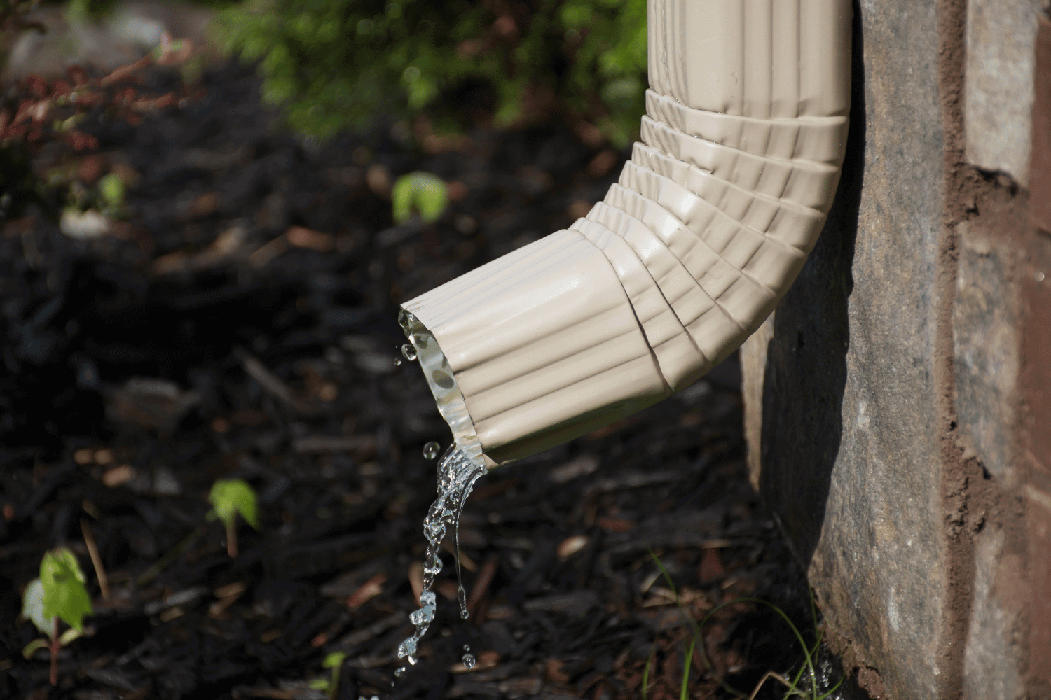 A properly installed downspout directing water away from the house foundation.