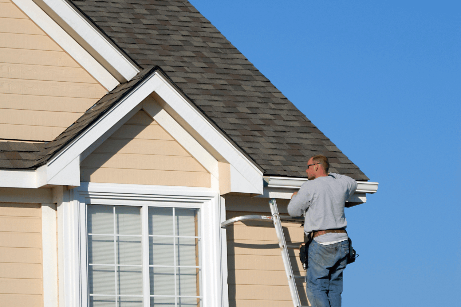 Essential tools for gutter installation including a drill and various gutter materials. 