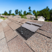 A house with a visibly damaged roof indicating the need for a roof replacement.
