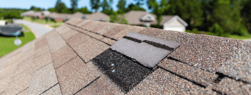 A house with a visibly damaged roof indicating the need for a roof replacement.