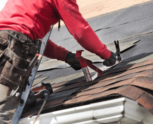 Installation of new roofing materials on a residential building.